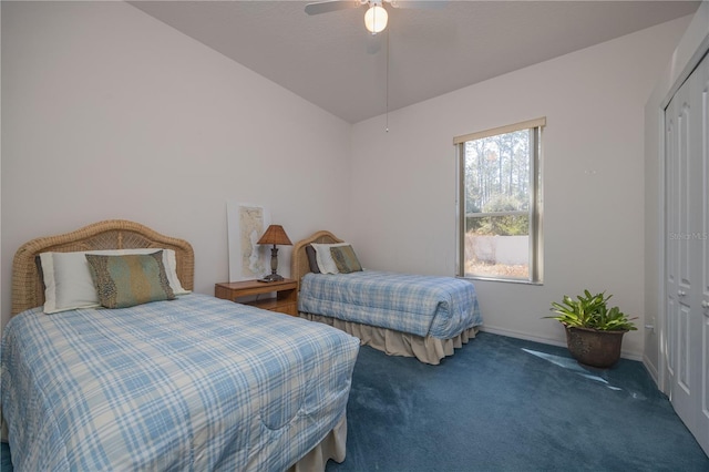 bedroom with a ceiling fan, baseboards, vaulted ceiling, a closet, and dark colored carpet