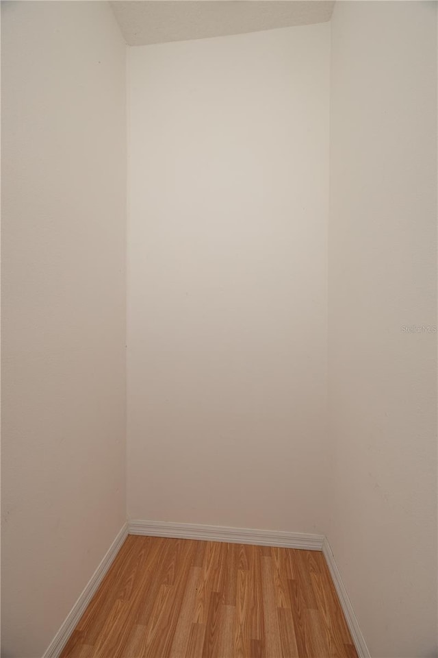 empty room with light wood-type flooring and baseboards