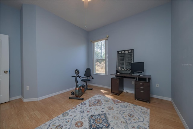 office featuring light wood-type flooring, vaulted ceiling, and baseboards