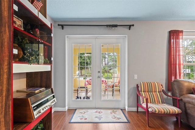 doorway to outside with french doors, wood finished floors, and baseboards