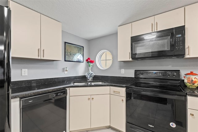 kitchen with dark stone counters, black appliances, a textured ceiling, and a sink