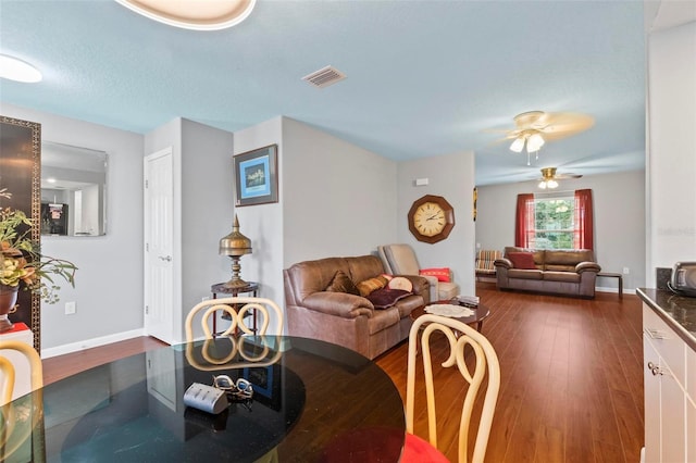 dining area with ceiling fan, dark wood-type flooring, visible vents, and baseboards