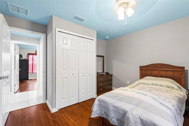 bedroom featuring a closet, dark wood finished floors, and visible vents