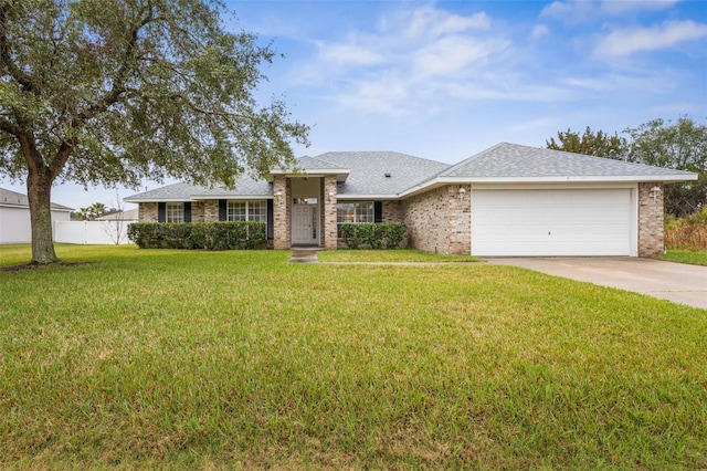 view of front of home with a garage, a front yard, concrete driveway, and fence