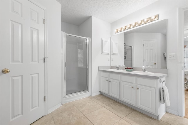 bathroom with tile patterned floors, a sink, and a shower stall