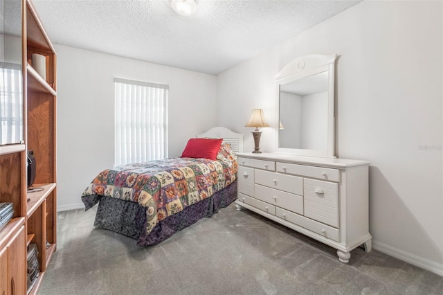 bedroom featuring a textured ceiling, multiple windows, dark carpet, and baseboards