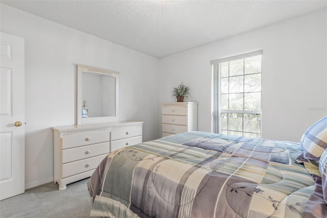 bedroom featuring light carpet and a textured ceiling