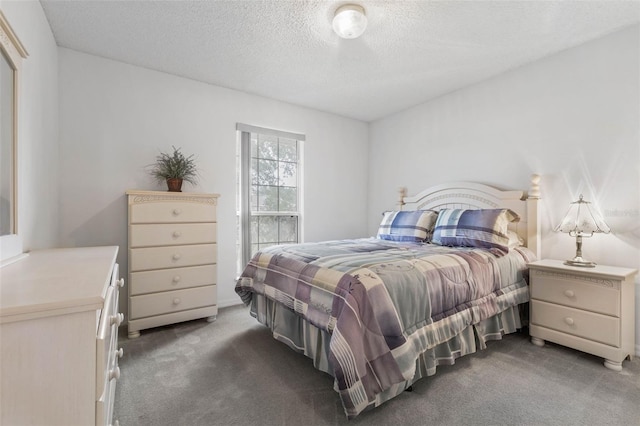 bedroom with dark carpet and a textured ceiling