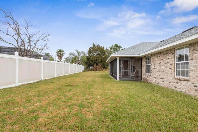 view of yard featuring a fenced backyard and a sunroom