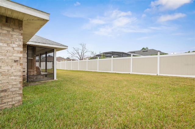 view of yard featuring a sunroom and fence