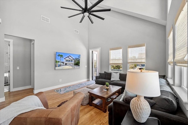 living room with baseboards, visible vents, and light wood-style floors