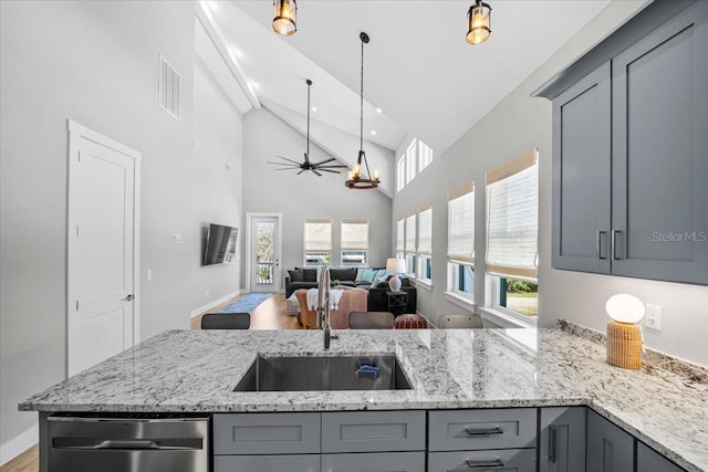 2737 John Bull, Flagler Beach, FL 32136 - kitchen with high vaulted ceiling, gray cabinetry, visible vents, stainless steel dishwasher, and light stone countertops