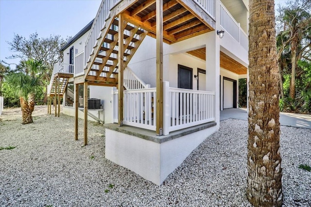 2737 John Bull, Flagler Beach, FL 32136 - view of side of home featuring an attached garage, stairs, and cooling unit