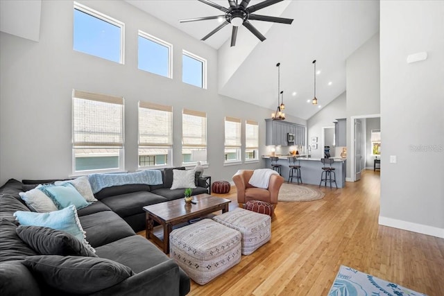2737 John Bull, Flagler Beach, FL 32136 - living area featuring light wood finished floors, a high ceiling, baseboards, and a ceiling fan