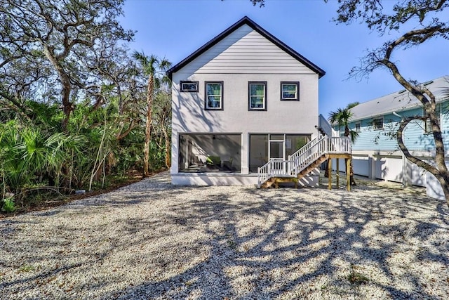 2737 John Bull, Flagler Beach, FL 32136 - rear view of house featuring a sunroom, stairs, and stucco siding