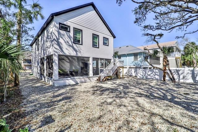 2737 John Bull, Flagler Beach, FL 32136 - rear view of house featuring a sunroom, stairs, and fence