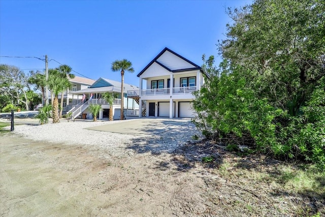 2737 John Bull, Flagler Beach, FL 32136 - coastal inspired home with a porch, gravel driveway, a garage, and stairs
