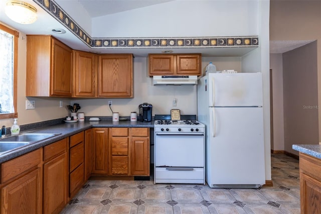 kitchen featuring white appliances, under cabinet range hood, and brown cabinets