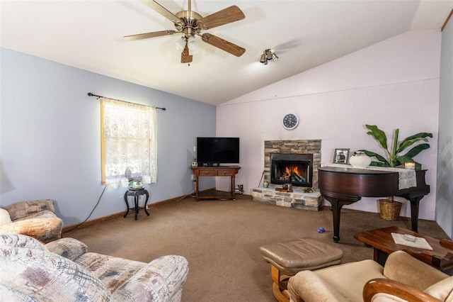 carpeted living area with baseboards, vaulted ceiling, a ceiling fan, and a stone fireplace