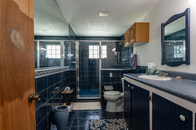 full bath with toilet, a textured ceiling, a wealth of natural light, and vanity