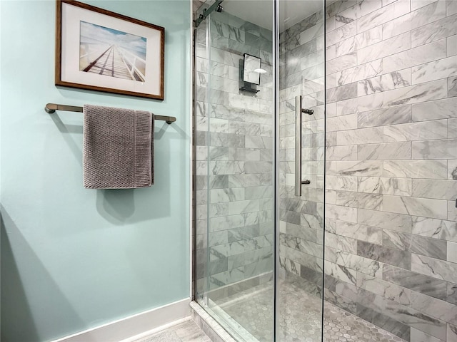 full bathroom featuring baseboards and tiled shower