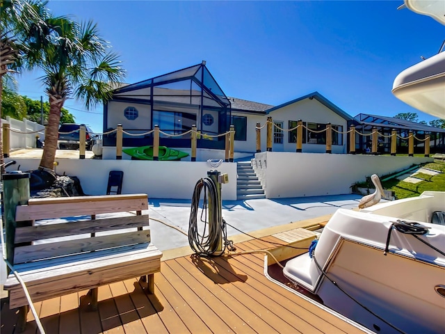 exterior space featuring a pool, glass enclosure, a patio, and fence