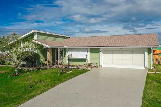 view of front facade featuring a garage, concrete driveway, and a front lawn