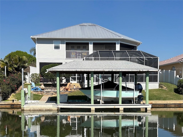 view of dock with a water view, boat lift, and a lanai