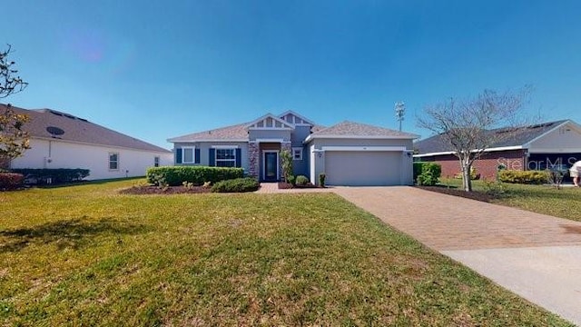 view of front of house featuring a front lawn, decorative driveway, and an attached garage