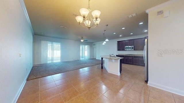 kitchen featuring stainless steel appliances, visible vents, open floor plan, light countertops, and decorative light fixtures