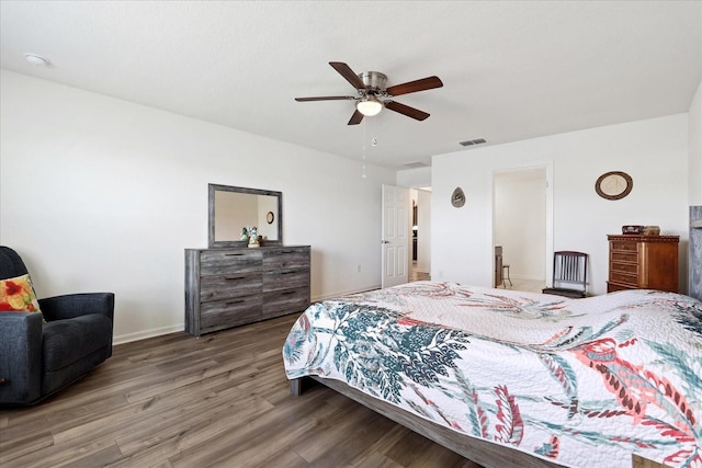 bedroom with a ceiling fan, baseboards, visible vents, and wood finished floors