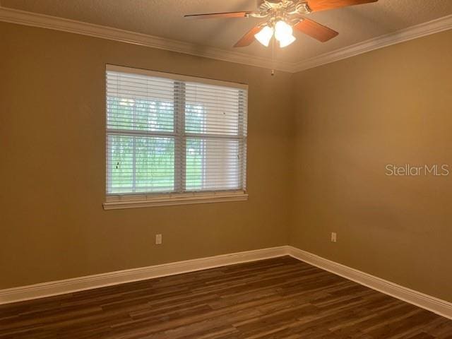 unfurnished room featuring dark wood-style floors, crown molding, a ceiling fan, and baseboards