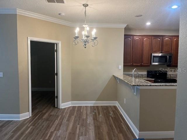 kitchen with dark wood-type flooring, black range with electric stovetop, stainless steel microwave, and baseboards