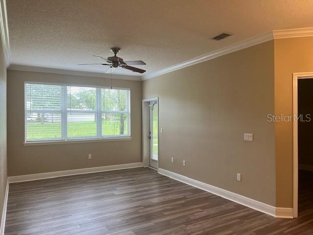 spare room with baseboards, ceiling fan, ornamental molding, dark wood-type flooring, and a textured ceiling