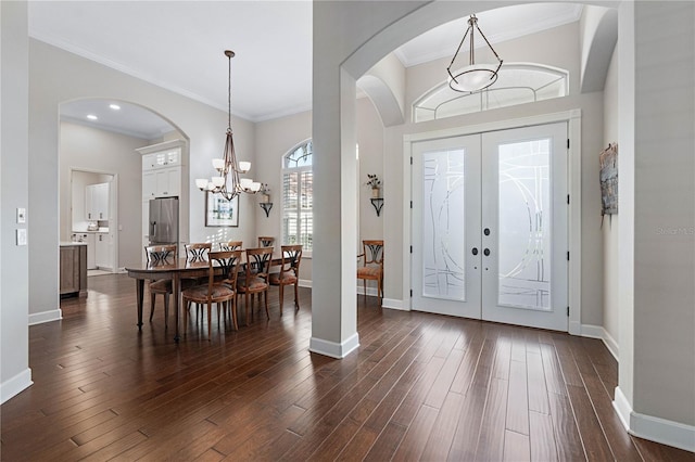 foyer entrance featuring an inviting chandelier, baseboards, dark wood finished floors, and french doors