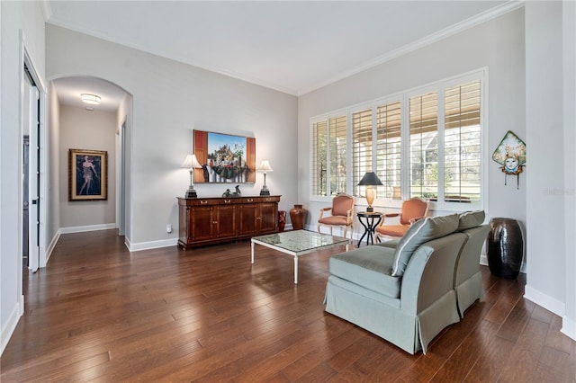 living area with baseboards, ornamental molding, arched walkways, and dark wood-type flooring