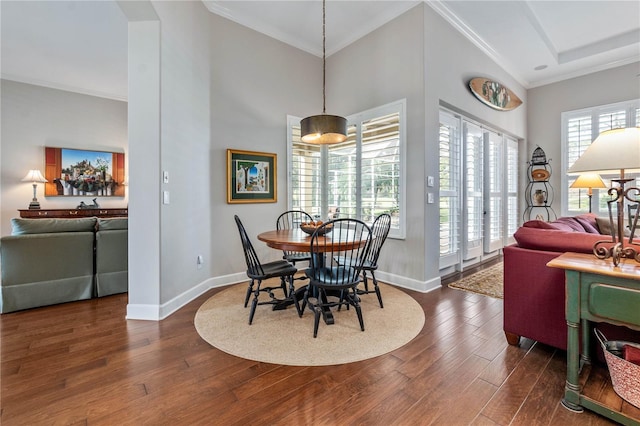 dining space featuring ornamental molding, dark wood-style flooring, a high ceiling, and baseboards