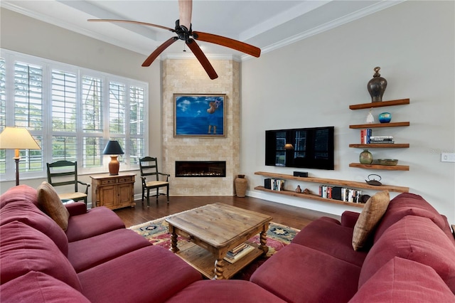 living room with a ceiling fan, dark wood-style flooring, a fireplace, and crown molding