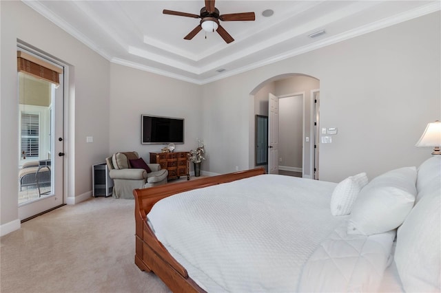 bedroom with access to exterior, arched walkways, a tray ceiling, visible vents, and light colored carpet