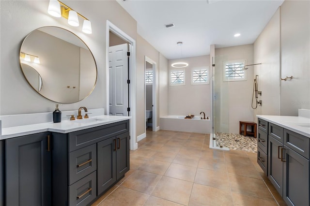 full bath with tile patterned flooring, two vanities, a sink, visible vents, and a shower stall