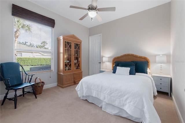 bedroom with baseboards, a ceiling fan, and light colored carpet