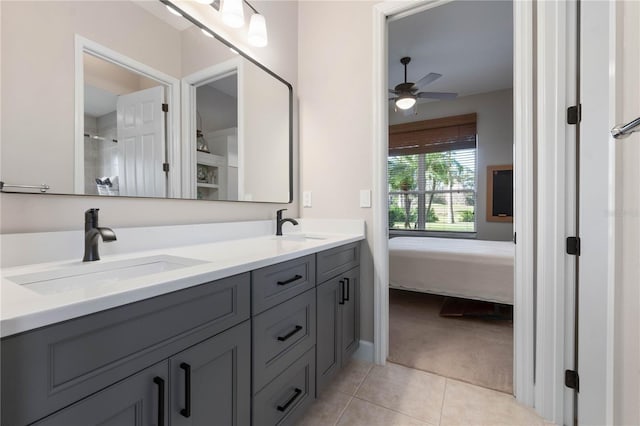 ensuite bathroom with ceiling fan, a sink, tile patterned floors, double vanity, and ensuite bath