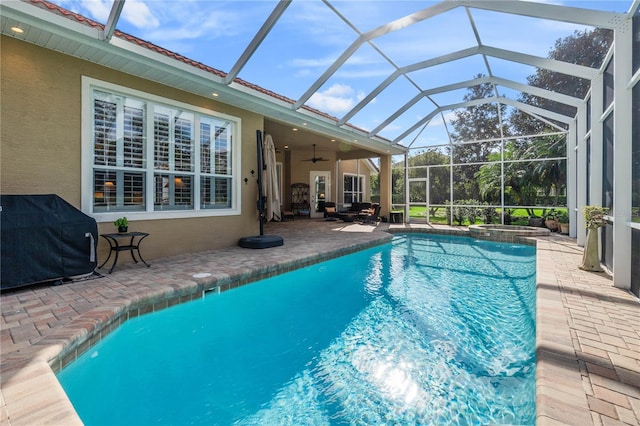 view of swimming pool featuring a ceiling fan, a patio, area for grilling, a lanai, and a pool with connected hot tub