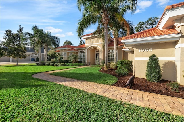 view of front of property with a front yard, a tiled roof, and stucco siding