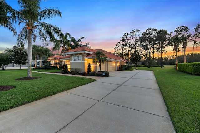 view of front of property with a garage, stucco siding, concrete driveway, and a yard