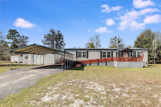 manufactured / mobile home featuring a carport, aphalt driveway, a front yard, and a wooden deck