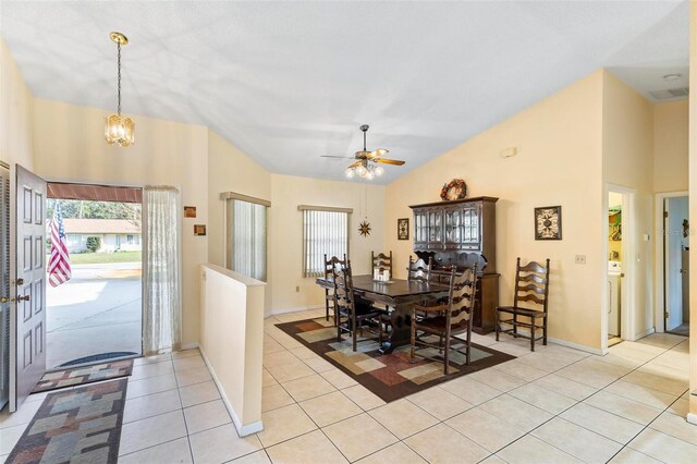 dining room featuring light tile patterned floors, baseboards, visible vents, high vaulted ceiling, and ceiling fan with notable chandelier