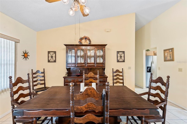 dining space with high vaulted ceiling, a ceiling fan, and light tile patterned flooring