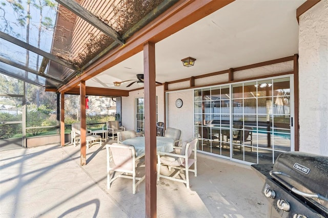 view of patio featuring outdoor dining space, glass enclosure, a grill, and ceiling fan