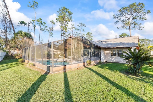 back of house with a yard, fence, a lanai, and an outdoor pool